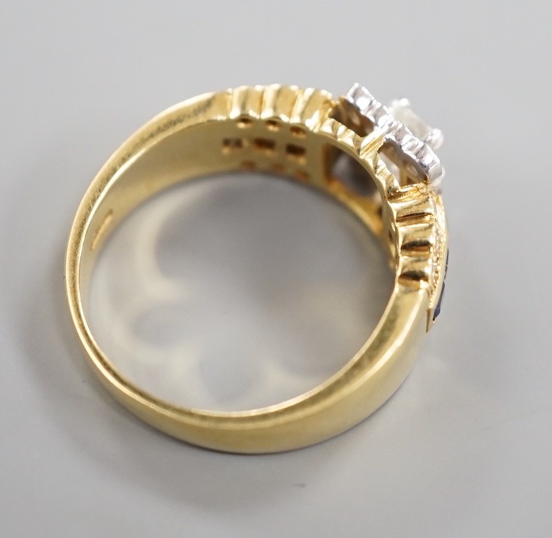 A modern 18ct gold, emerald and round cut diamond set square cluster ring, three three row sapphire and diamond set shoulders, size M, gross weight 6.6 grams.